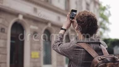 一个戴眼镜的家伙在欧洲旅行时用他的相机手机拍照。 游客用相机拍照